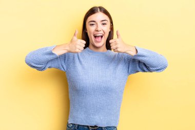 İspanyol güzel kadın gülümsüyor mutlu, pozitif, kendinden emin ve başarılı, her iki başparmağıyla