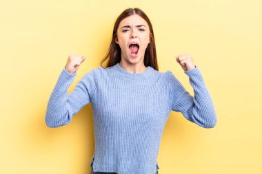 İspanyol asıllı güzel bir kadın öfkeli bir ifadeyle saldırganca bağırıyor ya da yumruklarıyla başarıyı kutluyor.