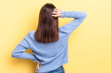 İspanyol güzel bir kadın bilgisiz ve kafası karışık hissediyor, bir çözüm düşünüyor, eli kalçasında, diğeri kafasında, dikiz aynasından.