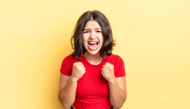 Genç ve güzel bir kız sinirli, sinirli, sinirli bakışlar ve sıkı yumruklarla bağırıyor. Öfkeli hissediyor.