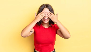 Genç güzel kız gülümsüyor ve mutlu hissediyor, iki eliyle gözlerini kapatıyor ve inanılmaz bir sürpriz bekliyor.