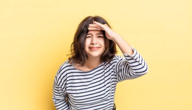 Genç ve güzel kız şaşkınlık ve şaşkınlık içinde bakıyor, el üstünde, uzaklara bakıyor, izliyor ya da arıyor.