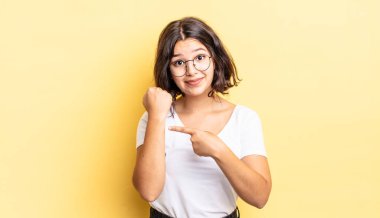 Genç ve güzel bir kız sabırsız ve kızgın görünüyor, saati gösteriyor, dakiklik istiyor, zamanında gelmek istiyor.