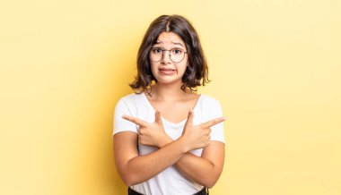 Şaşkın, kafası karışmış, güvensiz ve şüpheyle zıt yönlere bakan güzel bir kız.