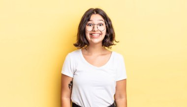 Genç ve güzel bir kız mutlu ve şapşal görünüyor. Geniş, eğlenceli, deli gülüşü ve gözleri açık.