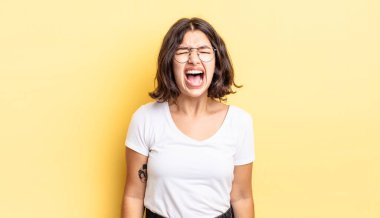 Genç ve güzel bir kız agresif bir şekilde bağırıyor, sinirli, sinirli, öfkeli ya da sinirli görünüyor.