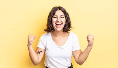 Genç, güzel bir kız mutlu, şaşırmış ve gururlu, bağırıyor ve başarıyı büyük bir gülümsemeyle kutluyor.