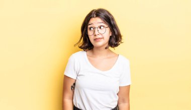 Genç güzel kız merak ediyor, mutlu düşünceler ve fikirler düşünüyor, hayal kuruyor, kenarda yer arıyor.