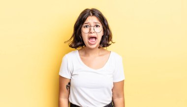 Genç ve güzel kız korkmuş ve şok olmuş hissediyor, ağzı açık bir şekilde şaşkınlık içinde.