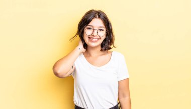 Genç ve güzel bir kız neşeli ve kendinden emin bir şekilde gülüyor. Sıradan, mutlu, dostane bir gülümsemeyle.