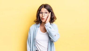 Genç ve güzel bir kız ağzı açık bir şekilde yüz yüze inanmayarak şok olmuş ve hayrete düşmüş hissediyor.