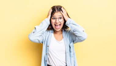 Genç ve güzel bir kız el ele tutuşuyor, ağzı açık, son derece şanslı, şaşırmış, heyecanlı ve mutlu hissediyor.