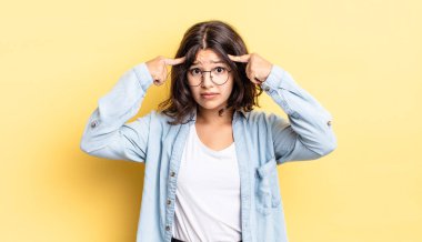 Ciddi ve konsantre görünümlü, beyin fırtınası yapan ve zorlu bir sorunu düşünen genç ve güzel bir kız.