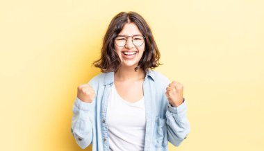 Genç, güzel bir kız zaferle bağırıyor, gülüyor, mutlu ve heyecanlı hissediyor başarıyı kutlarken.