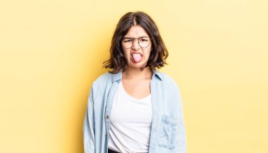 Genç, güzel bir kız, tiksinmiş ve rahatsız olmuş hissediyor. Dilini dışarı çıkarıyor, iğrenç ve iğrenç bir şeyden hoşlanmıyor.