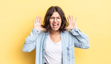 Genç ve güzel bir kız panik ya da öfke içinde bağırıyor, şok olmuş, korkmuş ya da öfkeli, elleri başının yanında.