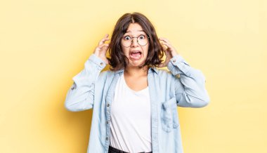 Genç ve güzel bir kız ellerini havaya kaldırarak bağırıyor. Öfkeli, sinirli, stresli ve üzgün.