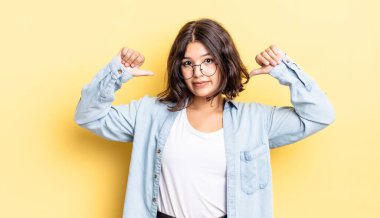 Genç, güzel bir kız gururlu, kibirli ve kendinden emin, tatmin olmuş ve başarılı görünüyor, kendini işaret ediyor.