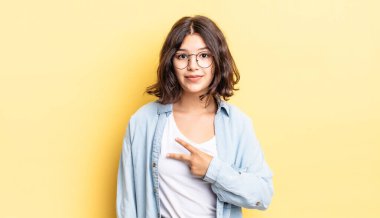 Genç, güzel bir kız mutlu, pozitif ve başarılı hissediyor. Göğsünde el yapımı V ile zafer ya da huzur gösteriyor.