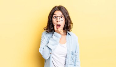 Ağzı ve gözleri açık, eli çenesinde genç ve güzel bir kız. Hoş olmayan bir şok geçiriyor.