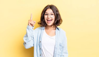 Genç ve güzel bir kız bir fikri fark ettikten sonra mutlu ve heyecanlı bir dahi gibi hissediyor, neşeli bir şekilde parmağını kaldırıyor, eureka!