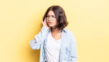 Genç ve güzel kız ciddi ve meraklı görünüyor, dinliyor, gizli bir konuşma ya da dedikodu duymaya çalışıyor, kulak misafiri oluyor.