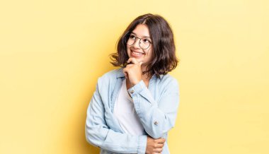 Genç güzel kız düşünceli, meraklı ya da hayal kuruyor, hayal kuruyor ve uzayı kopyalamak için yukarı bakıyor.