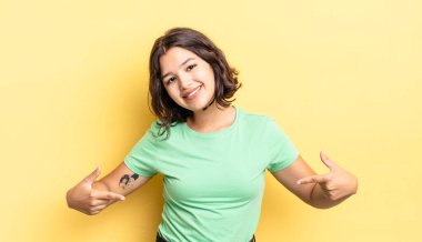 Genç, güzel bir kız gururlu, kibirli, mutlu, şaşırmış ve tatmin olmuş görünüyor, kendini gösteriyor, kazanan gibi hissediyor.