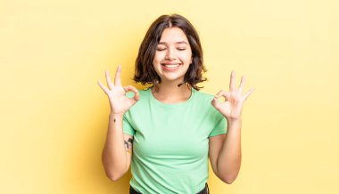 Genç ve güzel kız konsantre olmuş ve meditasyon yapıyor, kendini tatmin olmuş ve rahatlamış hissediyor, düşünüyor ya da bir seçim yapıyor.