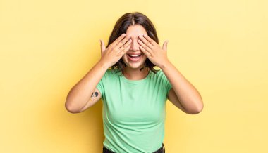 Genç güzel kız gülümsüyor ve mutlu hissediyor, iki eliyle gözlerini kapatıyor ve inanılmaz bir sürpriz bekliyor.