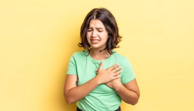 Genç, güzel bir kız üzgün, yaralı ve kalbi kırık görünüyor, iki elini de kalbe yakın tutuyor, ağlıyor ve bunalımda.