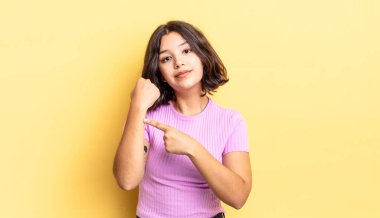 Genç ve güzel bir kız sabırsız ve kızgın görünüyor, saati gösteriyor, dakiklik istiyor, zamanında gelmek istiyor.