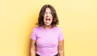 Genç ve güzel bir kız agresif bir şekilde bağırıyor, sinirli, sinirli, öfkeli ya da sinirli görünüyor.