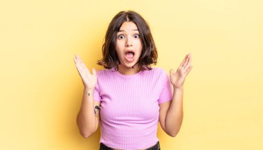 Genç ve güzel bir kız şok olmuş ve şaşkın görünüyor, inanılmaz bir şey fark ettiğinde çene şaşkın.