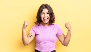 Genç, güzel bir kız mutlu, şaşırmış ve gururlu, bağırıyor ve başarıyı büyük bir gülümsemeyle kutluyor.