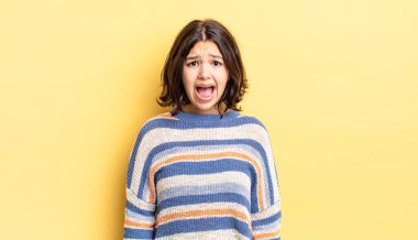 Genç ve güzel kız korkmuş ve şok olmuş hissediyor, ağzı açık bir şekilde şaşkınlık içinde.