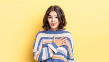 Genç ve güzel bir kız şok olmuş ve şaşırmış hissediyor, gülümsüyor, el ele tutuşuyor, o olmaktan mutlu ya da minnettarlık gösteriyor.