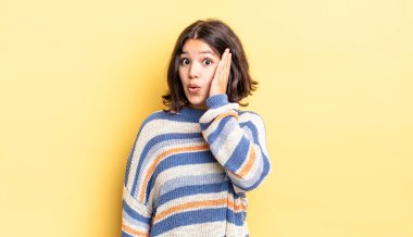 Genç ve güzel bir kız ağzı açık bir şekilde yüz yüze inanmayarak şok olmuş ve hayrete düşmüş hissediyor.