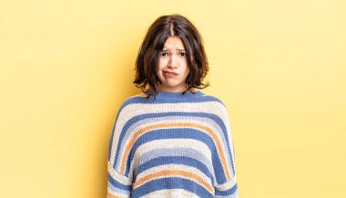 Genç ve güzel bir kız kafası karışık ve kuşkulu, merak ediyor ya da karar vermeye çalışıyor.