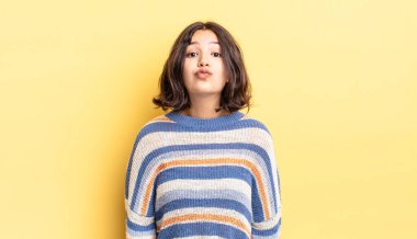 Genç ve güzel bir kız dudaklarını birbirine bastırıyor. Sevimli, eğlenceli, mutlu, sevimli bir yüz ifadesiyle. Öpücük gönderiyor.