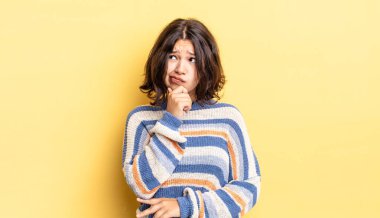 Genç güzel kız düşünüyor, kuşkulu ve şaşkın hissediyor, farklı seçeneklerle, hangi kararı vereceğini merak ediyor.