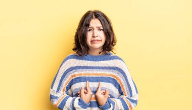 Genç ve güzel bir kız, şaşkın ve şaşkın bir bakışla kendini işaret ediyor. Seçildiğime şaşırmış ve şaşırmış.