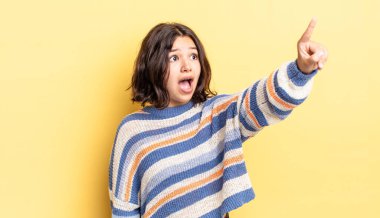 Genç, güzel bir kız şaşkın ve şaşırmış hissediyor. Şaşırmış ve ağzı açık bir şekilde hayranlıkla yukarı bakıyor.