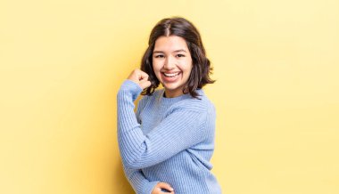 Genç, güzel bir kız kendini mutlu, tatmin olmuş ve güçlü hissediyor, kaslı ve formda, spor salonundan sonra güçlü görünüyor.