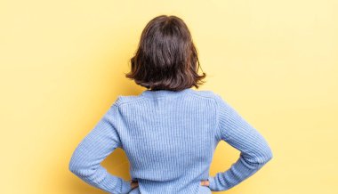 Genç, güzel bir kız, kafası karışık ya da dolu ya da şüphe ve soru dolu, merak ediyor, elleri kalçasında, dikiz aynasından.