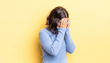 Genç ve güzel bir kız, üzgün, hayal kırıklığına uğramış bir bakışla gözleri kaplıyor, ağlıyor, yan gözle bakıyor.