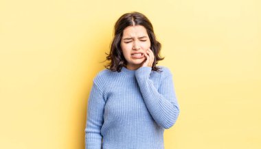 Genç, güzel bir kız, yanağını tutuyor ve ağrılı diş ağrısı çekiyor. Hasta, sefil ve mutsuz hissediyor. Dişçi arıyor.