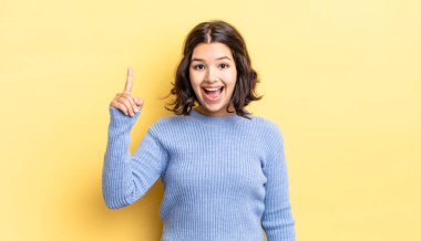 Genç ve güzel bir kız bir fikri fark ettikten sonra mutlu ve heyecanlı bir dahi gibi hissediyor, neşeli bir şekilde parmağını kaldırıyor, eureka!