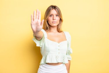 Sarışın, güzel bir kadın ciddi, sert, hoşnutsuz ve kızgın görünüyor.