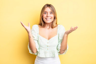 Sarışın, güzel bir kadın mutlu, heyecanlı, şaşırmış ya da şaşırmış hissediyor. İnanılmaz bir şeye gülümsüyor ve şaşırıyor.